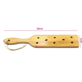 This is an image of a BDSM wooden paddle with holes, offering a spectrum of sensations for an erotic adventure.